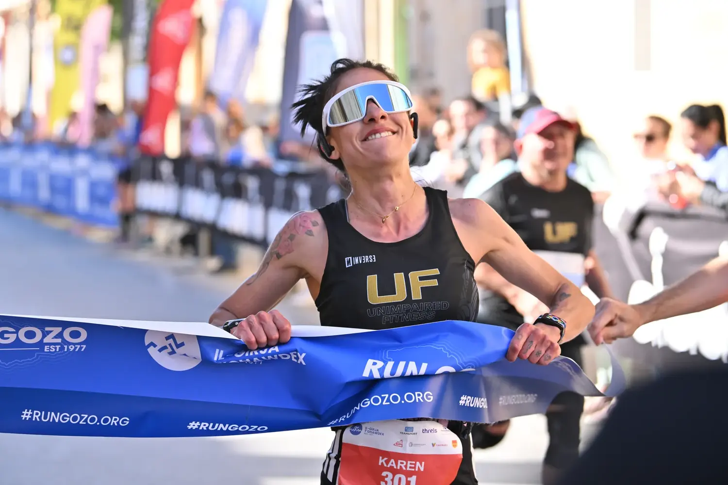 A runner breaking the finish tape